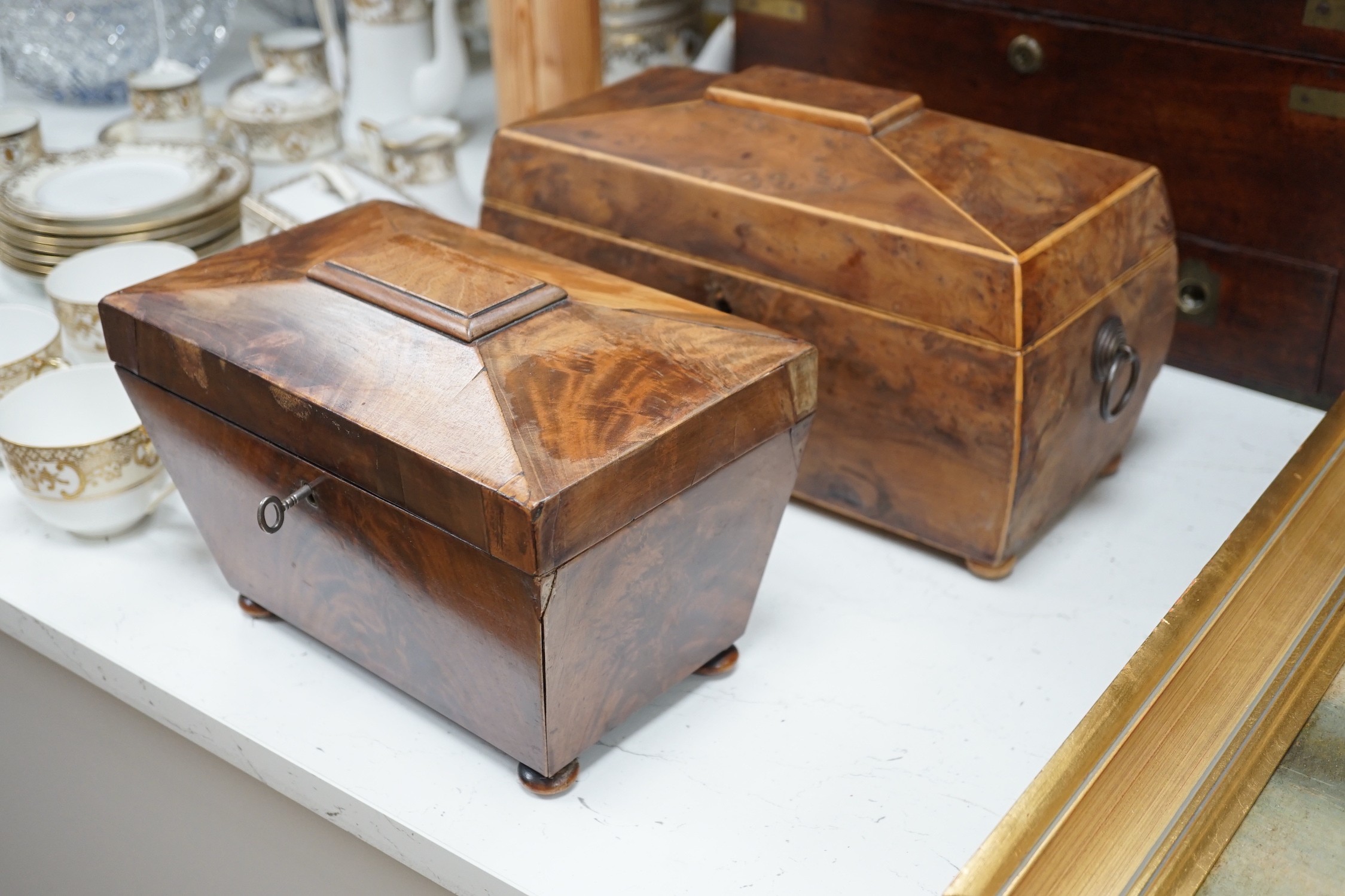 A Victorian boxwood strung burr yew sarcophagus shaped tea caddy, another mahogany tea caddy, a brass bound mahogany silver box with Bramah lock and another mahogany box. Largest 40cm wide